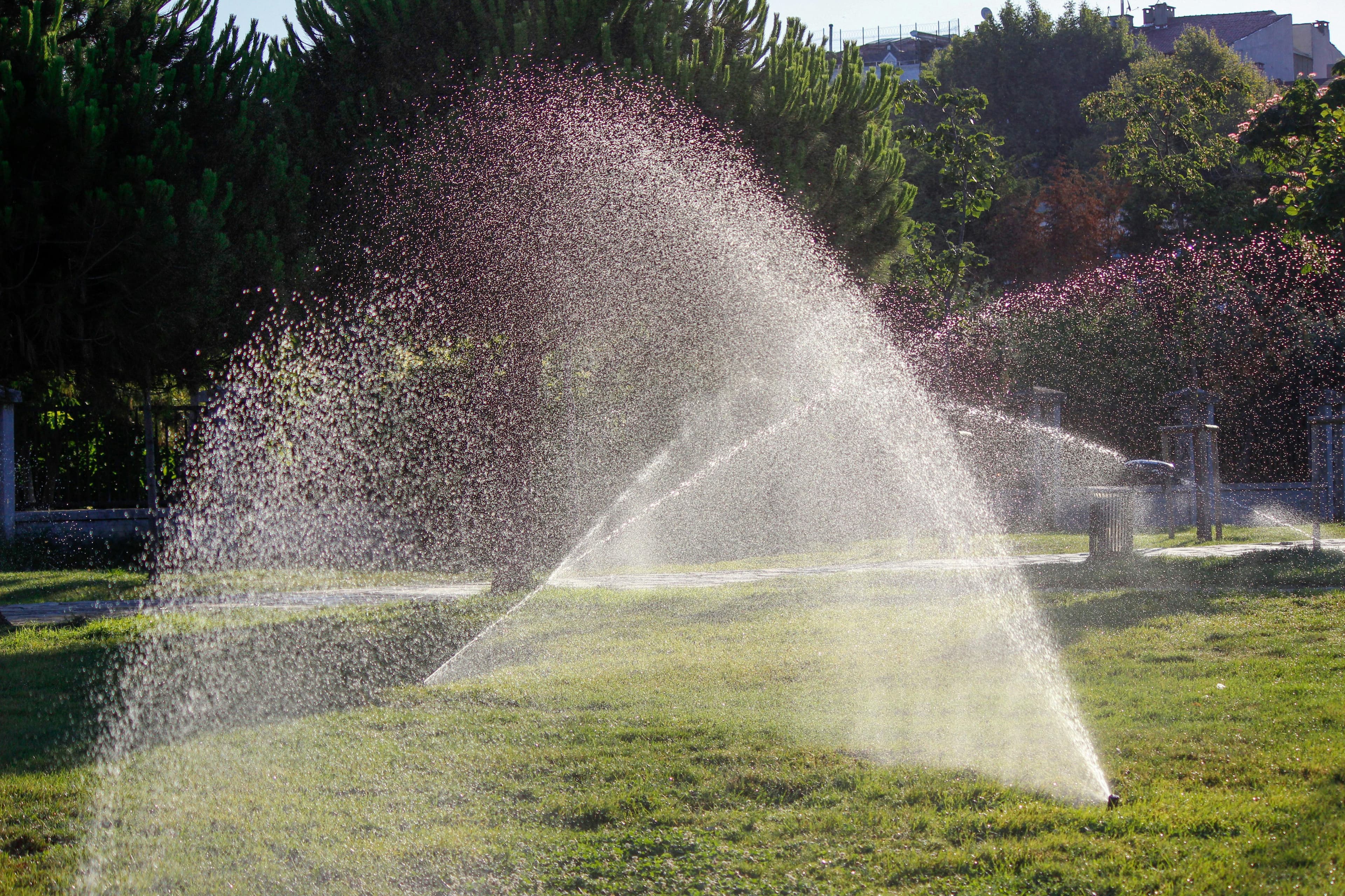 Sprinkler system watering a green lawn